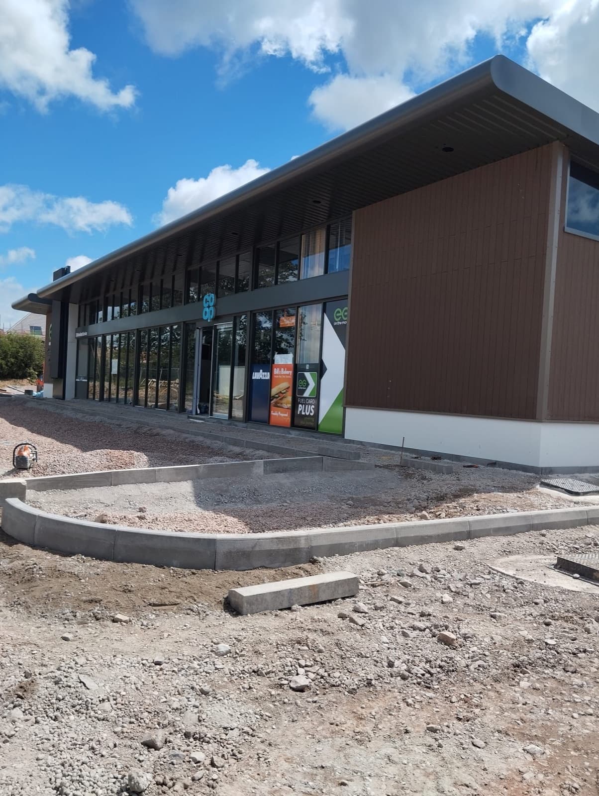 Kerbing and drainage works in progress outside a commercial building