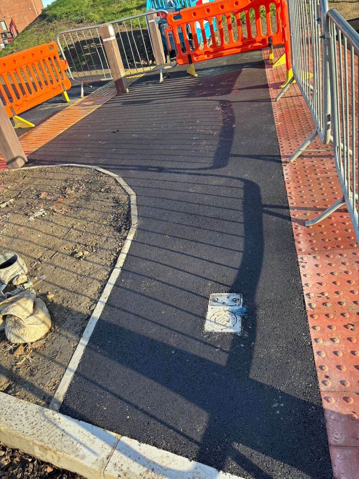 New pedestrian surfacing beside tactile paving and safety barriers